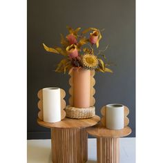 a vase with flowers and two candles sitting on top of it