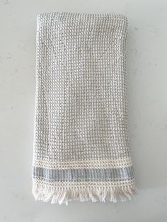 a white and grey towel hanging on a wall