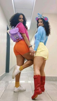 two women in short shorts and boots posing for the camera