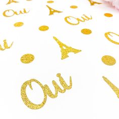 gold glitter confetti on white paper with the word out written in black ink