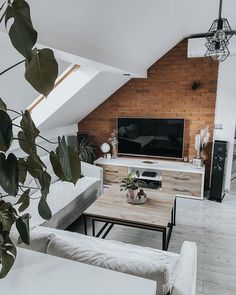 a living room filled with furniture and a flat screen tv on top of a wooden table