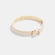 This bright enamel bangle features our sculpted Signature. It easily snaps open and shut with a hinged closure. | Coach Sculpted Signature Enamel Hinged Bangle Bracelet - Women's - Gold/chalk Coach Bracelets, Coach Bangle, Coach Tabby, Enamel Bangle, Gold Bracelet For Women, Hinged Bangle, Gold Bangles, Christmas List, Bangle Bracelet