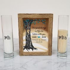 two shot glasses and a wooden box with an image of a tree on the inside