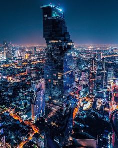 an aerial view of the city at night with skyscrapers lit up in bright lights