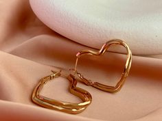 These elegant heart-shaped gold-plated stainless steel earrings add a touch of romance and elegance to every moment. Crafted from high-quality steel, these earrings are suitable for both daily wear and special occasions. Key Features: Gold-Plated Romance: The earrings offer a romantic look with their gold plating. The heart-shaped design is ideal for expressing deep emotions. High-Quality Steel: Crafted from high-quality stainless steel, these earrings maintain their long-lasting shine and durability. They are suitable for daily wear and won't fade. Graceful and Lightweight Design: These earrings provide a comfortable fit with their graceful and lightweight structure. They complement any outfit perfectly. Wonderful Gift Option: These heart-shaped gold-plated stainless steel earrings are a Thick Hoop Earrings, Heart Earring, Square Necklace, Heart Hoop Earrings, Romantic Gestures, Heart Shaped Earrings, Steel Earrings, Men Earrings, Hypoallergenic Earrings