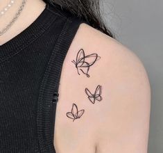 three butterflies tattoo on the back of a woman's left shoulder and upper arm