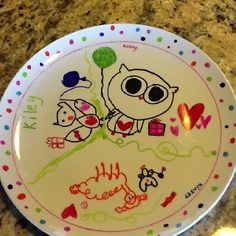 a plate with drawings on it sitting on a counter