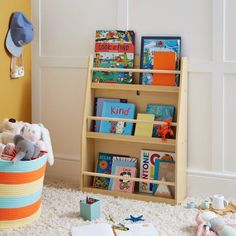 a child's bookshelf in the corner of a room filled with toys