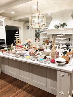 a kitchen filled with lots of food on top of a white counter topped with plates and bowls