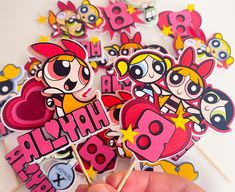 a hand holding some lollipops with cartoon characters on them and the words happy birthday