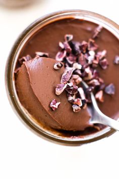 there is a chocolate cake on a plate with a spoon in it and sprinkles