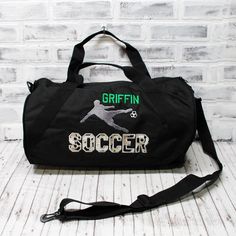 "Score a big GOAL with this super fun kids soccer bag!   SEE PHOTOS FOR SIZE CHARTS AND POLICIES ABOUT OUR BAGS: 🐉 Choose a 12x18\" zipper top tote, OR small duffel - 18\", large duffel - 24\". Style and size chart shown in photos. PLEASE CHOOSE CAREFULLY. 🐉 Embroidered on a denier polyester bag- Made with 50% recycled material. Small bag has a single zippered main compartment, with a diagonal webbing handle and detachable adjustable barrel shoulder strap. Large bag also has a side zipper pocket. Tote bag has no pockets, but zips at the top and is made from the same sturdy material. 🐉 Should you choose a bag color not shown in photograph, the colors in the design will be remixed to stand out. Production Time: ⮚Production time is SHOWN IN THE CART, and ranges from 5-10 business days, dep Detachable Strap Duffle Bag For On-the-go, Duffle Bag With Detachable Handle For On-the-go, Cheap Duffle Bag With Multiple Compartments For On-the-go, Sporty Duffle Bag With Zipper Closure For On-the-go, Soccer Bag, Black Duffle Bag With Detachable Handle For On-the-go, Black Duffle Bag, Kids Soccer, Coach Gift