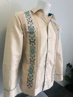 Beautiful Elegant Handcrafted Guayabera Shirt  Green Embroidery and Contrast  Beige Color Linen With Double Embroidery  Made in Merida Yucatan Mexico 100% Fine Linen Short Sleeve  Cross Stitch Embroidery Technique  High Quality Product  100% New Product.  New Inventory of 2024  Thank You and God bless you. We gladly accept returns and exchanges with these terms and conditions.  25% Fee on Returns   (This helps compensate for shipping fees, packing supplies and labor costs)  Exchanges have no cost.  Customer is responsible for shipping items back. We do not provide prepaid labels.  Items should be returned just as received and with no damages or signs of wear. Fitted Long Sleeve Embroidered Cotton Fabric, Summer Long Sleeve Traditional Wear With Intricate Embroidery, Embroidered Long Sleeve Traditional Wear For Summer, Summer Traditional Wear With Floral Embroidery And Long Sleeves, Mexican Fashion Men, Traditional Long Sleeve Kurta With Tonal Embroidery, Beige Fitted Traditional Wear With Long Sleeves, Spring Traditional Wear With Multicolor Embroidery And Long Sleeves, Traditional Long Sleeve Kurta With Geometric Embroidery