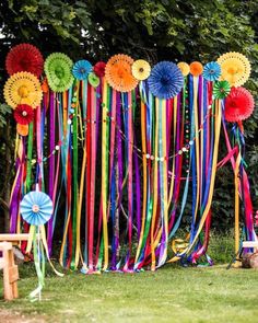 colorful streamers and ribbons are hanging on the wall in front of a picnic table