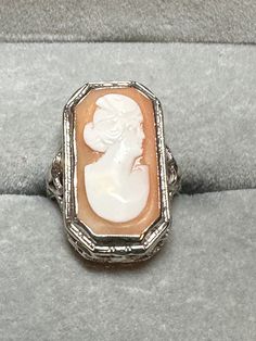 A stunning, 14 karat white gold Edwardian filigree cameo ring for your consideration. This beautiful piece is hallmarked as 14 karat and guaranteed to be such. The right facing cameo is rectangular with a decorative bezel setting. The cameo measures 32mm x 12.5 mm. The setting is a true, very intricate and traditional Edwardian style, very decorative and well crafted. This beautiful piece is a size 5, and weighs in at 3g. It would be a perfect addition to a cameo lovers collection! Pink Gift Wrap, Tiffany Earrings, Edwardian Style, Cameo Ring, Edwardian Fashion, Diamond Cluster Ring, Pink Gifts, Size 10 Rings, May 22