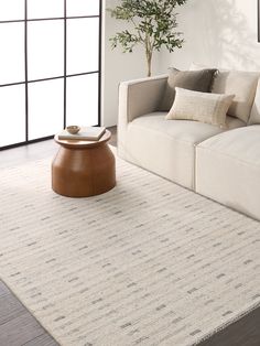 a living room with a couch, coffee table and potted plant