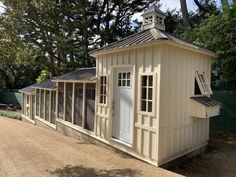 a small white building sitting next to a forest