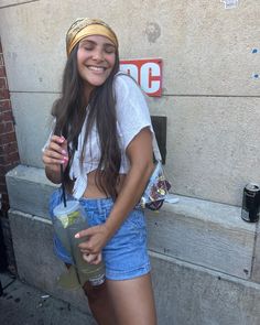 a young woman holding a drink and smiling