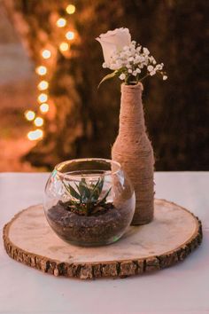 a vase filled with flowers sitting on top of a wooden table next to a fish bowl