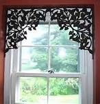 the window is decorated with black leaves and has a white valance on it's side