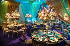 the tables are set up with blue and gold linens for an elegant wedding reception