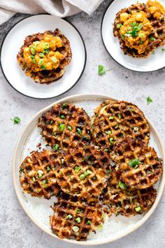 two plates with waffles on them and some green onions