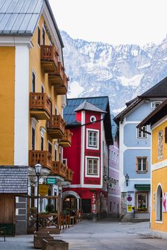 an empty street with buildings and mountains in the background