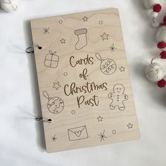 a wooden notebook with the words cards of christmas past written on it next to ornaments