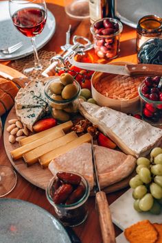 an assortment of cheeses, crackers and olives on a platter