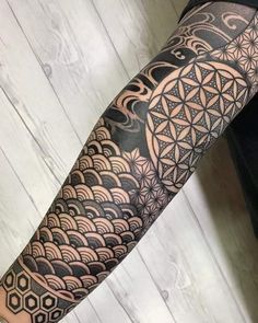 a man's arm with an intricate flower of life tattoo on the left forearm