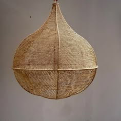 a hanging basket made out of woven material with a wooden hook on the end and two strings attached to it