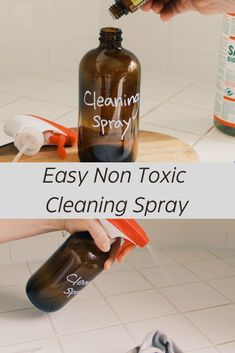 a person is cleaning a brown bottle with a sprayer on the counter and another hand holding a small orange container