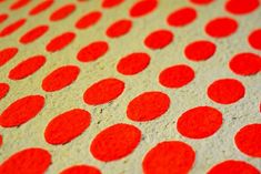 red circles are arranged on the surface of a white tablecloth that has been decorated with orange dots