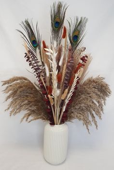 a white vase filled with feathers on top of a table