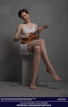 a woman sitting on top of a white stool holding a ukulele in her right hand