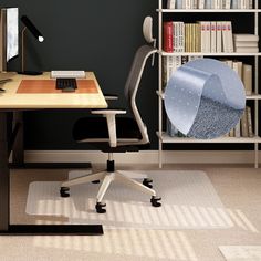 a desk with a chair, computer and bookshelf in the background