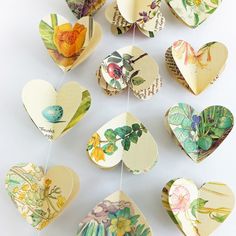 paper hearts hanging from strings with flowers on them