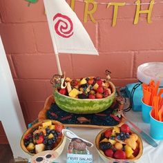 a table topped with lots of fruits and veggies next to a sign that says birth