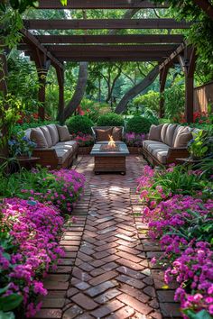 an outdoor living area with brick pavers and flowers in the foreground, surrounded by greenery