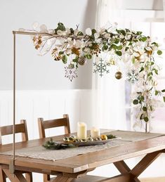 a wooden table topped with white plates and silverware next to a snowflake