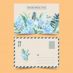 two envelopes with blue flowers and green leaves on the front, one has a postcard