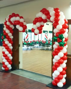 an arch decorated with red and white balloons