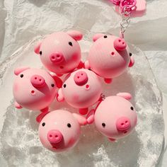 small pink pig keychains sitting on top of a glass plate