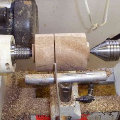 a machine that is making some kind of thing out of wood and metal pipe cutters