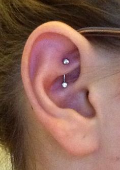 a woman's ear with two piercings on it