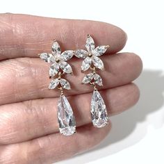 a pair of earrings in the palm of someone's hand