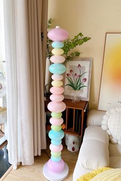 there is a tall lamp made out of balloons on the floor in front of a window