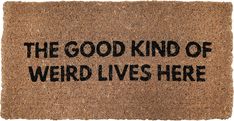 a door mat that says the good kind of weird lives here written in black ink