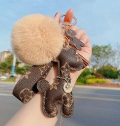 a woman holding up her hand with some charms on it