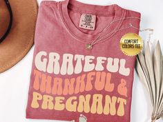 Looking for a funny way to say you're expecting? These Thanksgiving pregnancy shirts are for you! These pregnancy Thanksgiving shirts are a must-have pregnant couples shirts for those who want to celebrate Thanksgiving while announcing their pregnancy. This retro Grateful Thankful And Pregnant t-shirt is direct to garment printed on Comfort Colors Crewneck T-shirts, ensuring vibrant and long-lasting colors. The shirt is made from 100% combed and ring-spun cotton, providing a comfortable and soft Thanksgiving Pregnancy Shirt, Couples Shirts, Groovy Font, I'm Pregnant, Pregnant Couple, Thanksgiving Shirt, Comfort Colors Shirt, Pregnancy Shirts, Thanksgiving Shirts